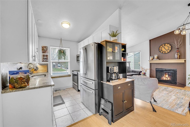 kitchen with a sink, appliances with stainless steel finishes, white cabinetry, and healthy amount of natural light