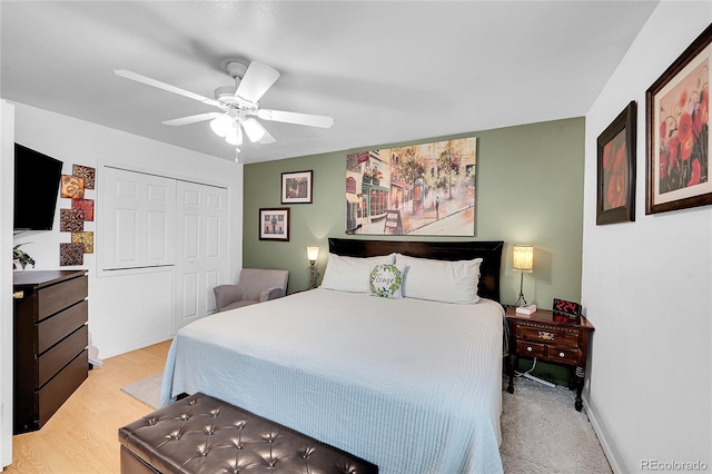 bedroom with ceiling fan, a closet, light wood-style floors, and baseboards