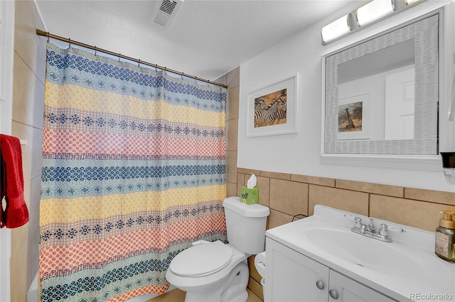 full bathroom featuring tile walls, toilet, vanity, a shower with curtain, and a wainscoted wall