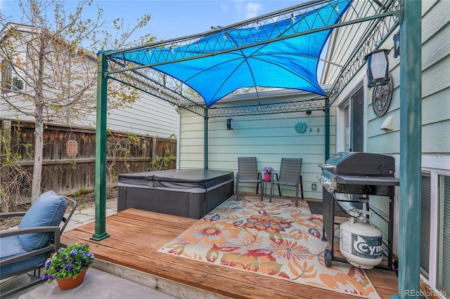 wooden deck with a hot tub and fence
