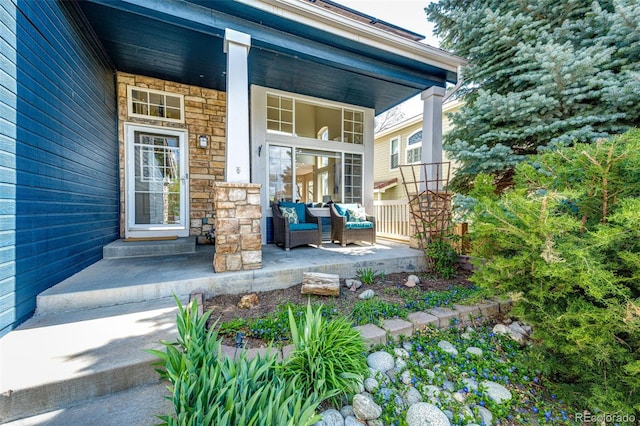 view of exterior entry with a porch and stone siding