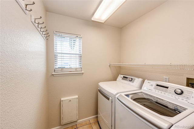 laundry room with independent washer and dryer, laundry area, baseboards, and light tile patterned floors