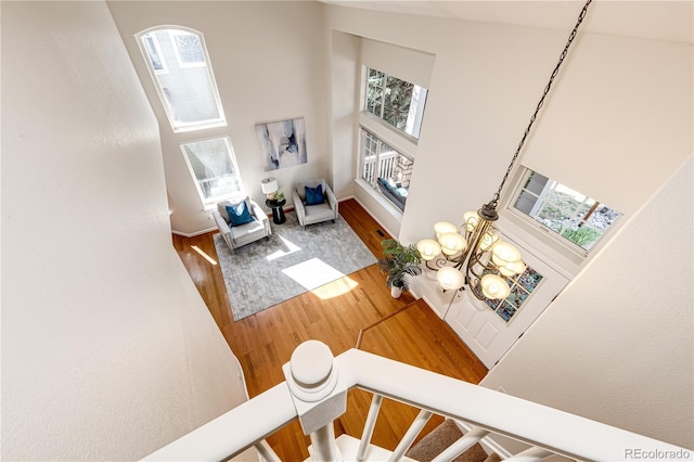 living area featuring a high ceiling, a wealth of natural light, and wood finished floors