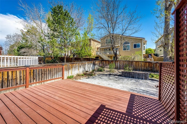 wooden deck featuring a fenced backyard and a patio area