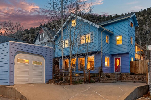 2041 Virginia St, Idaho Springs, CO 80452 - view of front of house with concrete driveway, a garage, and fence