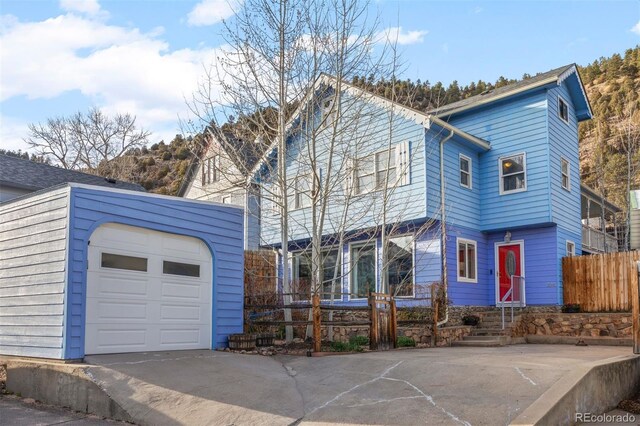 2041 Virginia St, Idaho Springs, CO 80452 - view of front of property with fence, a garage, and an outdoor structure