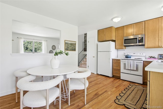235 Summit Cir, Lafayette, CO 80026 - kitchen featuring white appliances, light countertops, light wood-style floors, and tasteful backsplash