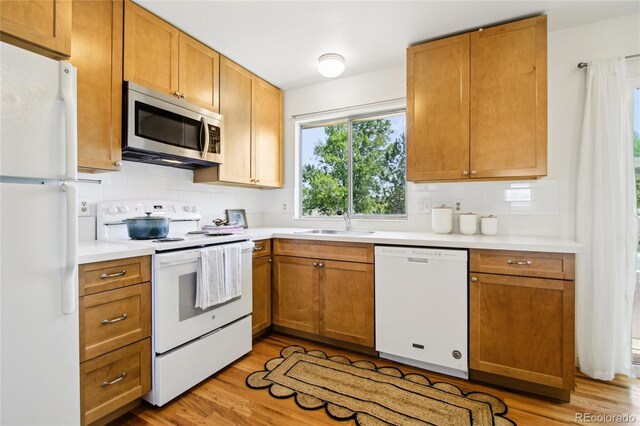 235 Summit Cir, Lafayette, CO 80026 - kitchen with white appliances, tasteful backsplash, a sink, and light countertops
