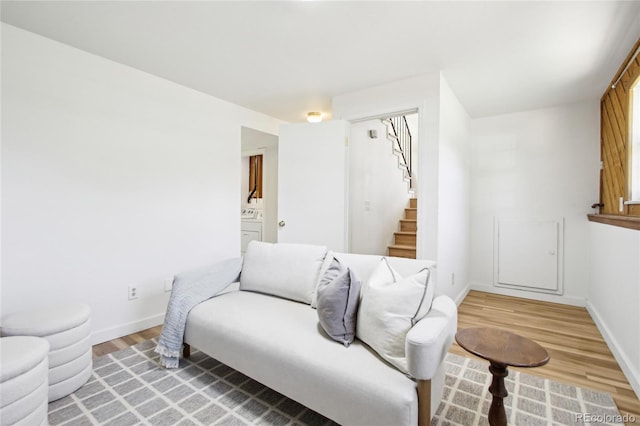 235 Summit Cir, Lafayette, CO 80026 - living area featuring stairway, light wood finished floors, washer / dryer, and baseboards