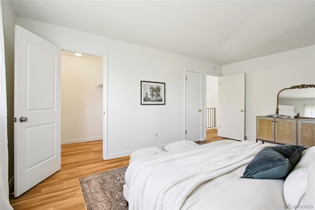 235 Summit Cir, Lafayette, CO 80026 - bedroom featuring light wood-style floors, baseboards, and a spacious closet