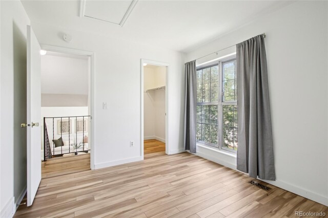 235 Summit Cir, Lafayette, CO 80026 - unfurnished bedroom featuring light wood-style floors, a spacious closet, baseboards, and a closet