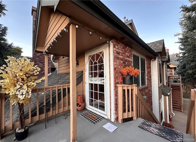 view of home's exterior featuring brick siding and a shingled roof