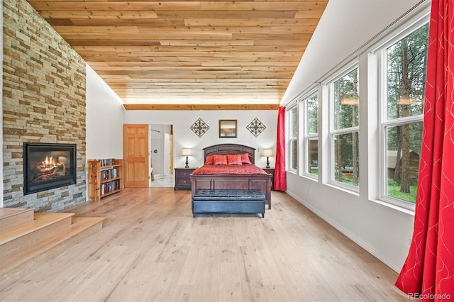 26499 W St, Conifer, CO 80433 - bedroom featuring wood ceiling, lofted ceiling, wood finished floors, and a stone fireplace
