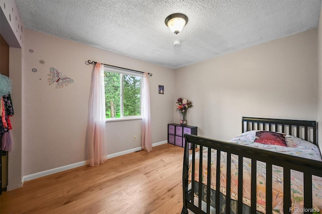26499 W St, Conifer, CO 80433 - bedroom with light wood finished floors and a textured ceiling