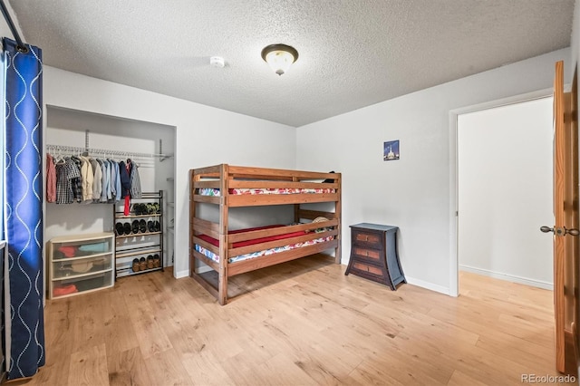 26499 W St, Conifer, CO 80433 - bedroom with wood finished floors, a closet, and a textured ceiling
