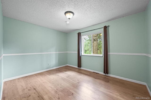 26499 W St, Conifer, CO 80433 - empty room with wood finished floors and a textured ceiling