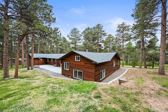 26499 W St, Conifer, CO 80433 - view of property exterior with a shingled roof, a lawn, and a patio