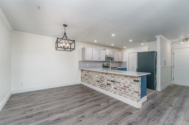 12118 W Dorado Pl Unit 206, Littleton, CO 80127 - kitchen featuring freestanding refrigerator, a peninsula, stainless steel microwave, light countertops, and wood finished floors