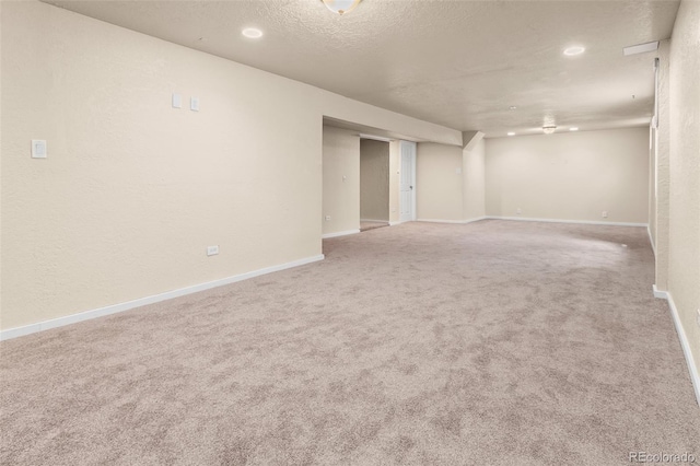empty room with carpet flooring, baseboards, recessed lighting, and a textured ceiling