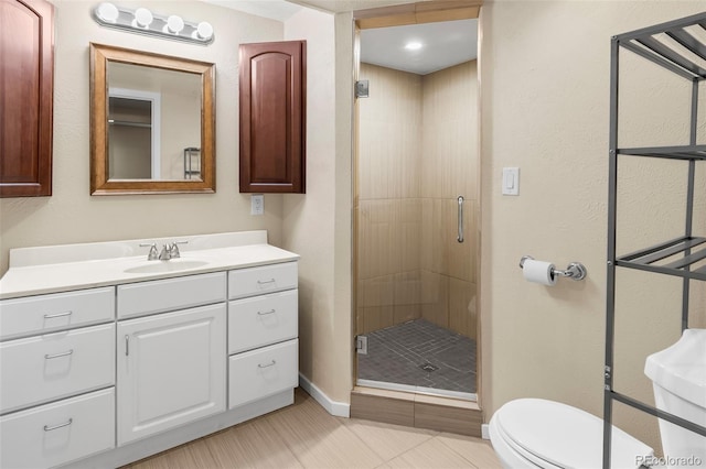 full bathroom with a shower stall, toilet, baseboards, vanity, and tile patterned flooring