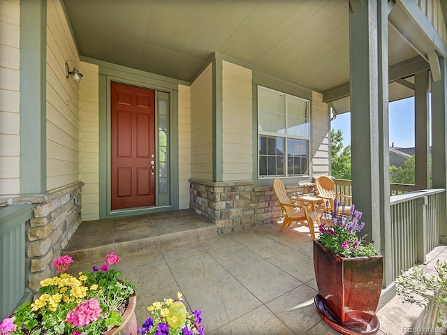 10565 Kicking Horse Dr, Littleton, CO 80125 - view of exterior entry featuring covered porch and stone siding