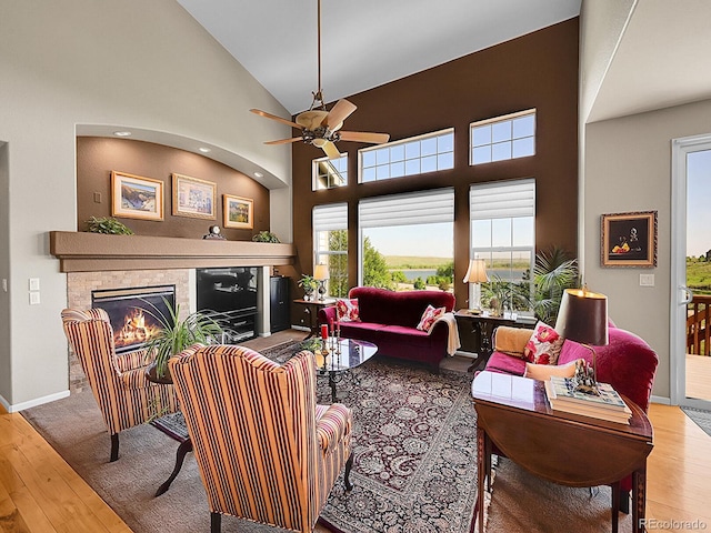 10565 Kicking Horse Dr, Littleton, CO 80125 - living room featuring hardwood / wood-style flooring, a ceiling fan, a tiled fireplace, and high vaulted ceiling