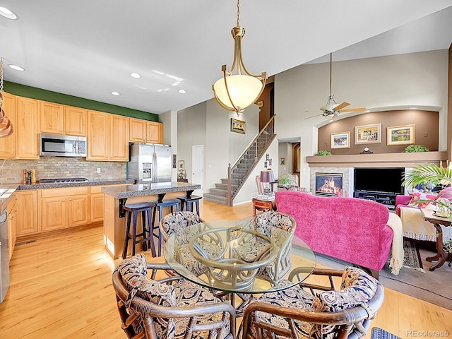 10565 Kicking Horse Dr, Littleton, CO 80125 - dining area featuring a tiled fireplace, stairway, recessed lighting, light wood-style flooring, and a ceiling fan