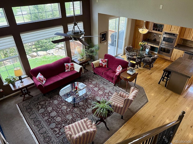 10565 Kicking Horse Dr, Littleton, CO 80125 - living room featuring light wood-type flooring, a ceiling fan, and a towering ceiling