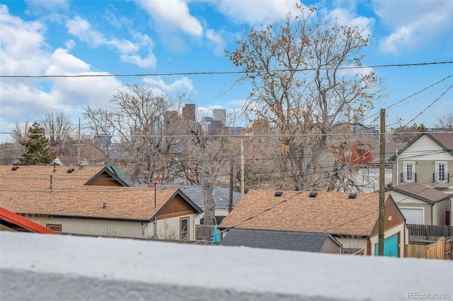 exterior space with roof with shingles and fence