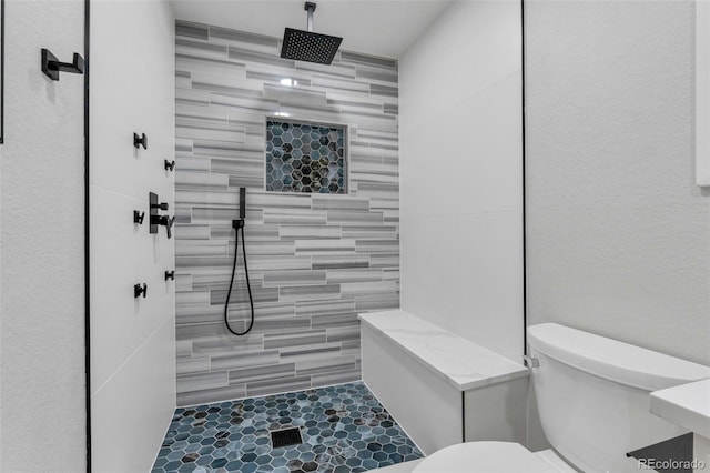 bathroom with tiled shower and toilet