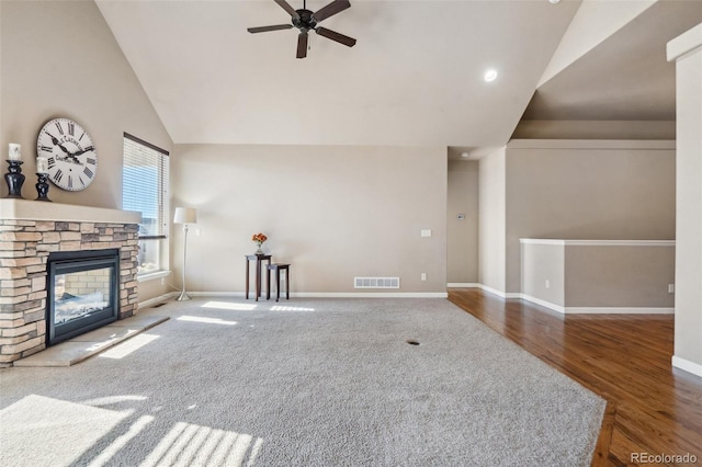 unfurnished living room featuring ceiling fan, a fireplace, vaulted ceiling, and hardwood / wood-style flooring