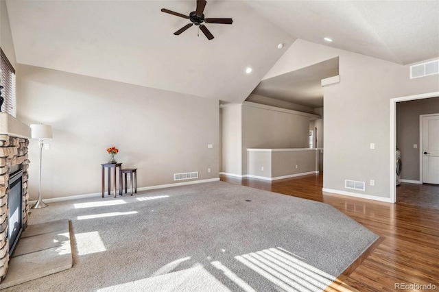 living room featuring lofted ceiling, ceiling fan, dark hardwood / wood-style floors, a fireplace, and washer / clothes dryer