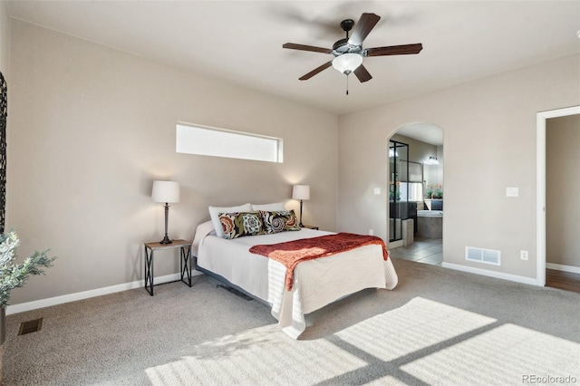 carpeted bedroom featuring ensuite bath and ceiling fan