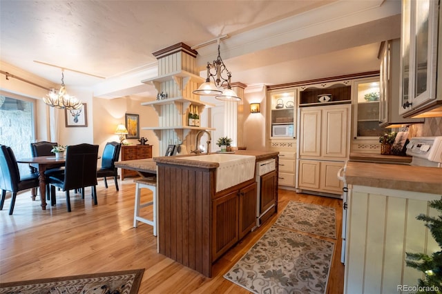 765 Columbine St Unit C203, Breckenridge, CO 80424 - kitchen with open shelves, white microwave, a chandelier, glass insert cabinets, and light wood-type flooring
