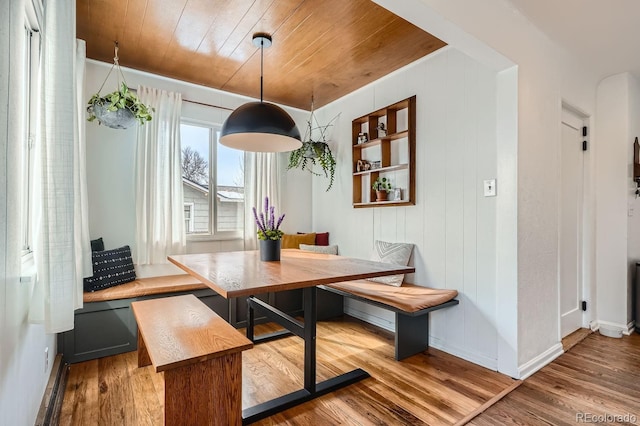 dining area with breakfast area, wood finished floors, wood ceiling, and baseboards