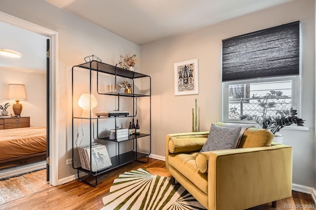 living area with baseboards and wood finished floors