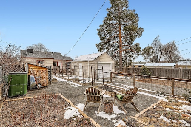 view of yard featuring an outdoor structure, a vegetable garden, fence, and a detached garage