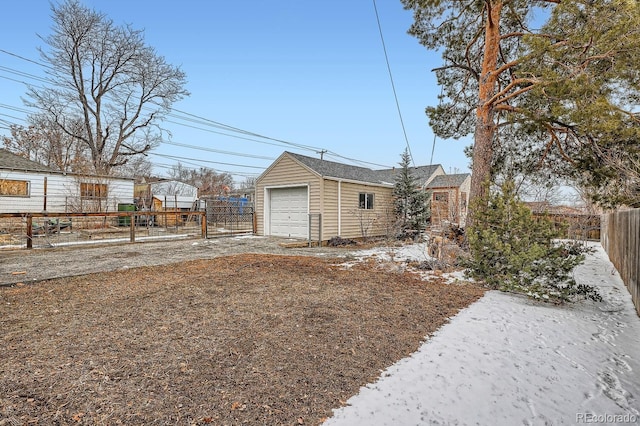 view of yard with an outbuilding, driveway, a detached garage, and fence