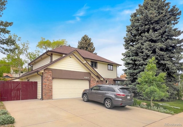 7217 S Zephyr Way, Littleton, CO 80128 - traditional home featuring brick siding, fence, driveway, and an attached garage