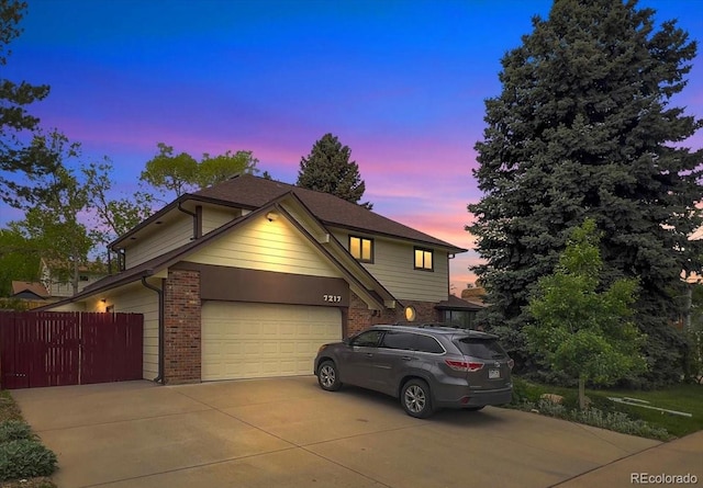 7217 S Zephyr Way, Littleton, CO 80128 - traditional-style home with concrete driveway, fence, brick siding, and a garage