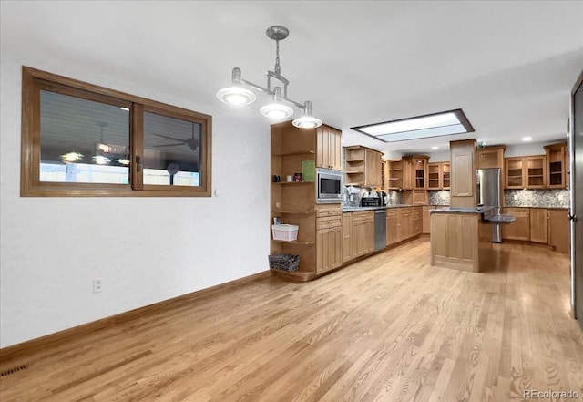 7217 S Zephyr Way, Littleton, CO 80128 - kitchen with stainless steel appliances, open shelves, light wood finished floors, a kitchen island, and glass insert cabinets