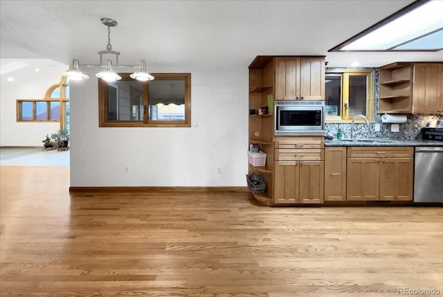 7217 S Zephyr Way, Littleton, CO 80128 - kitchen with open shelves, a sink, appliances with stainless steel finishes, and light wood-style flooring