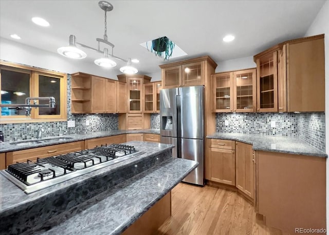 7217 S Zephyr Way, Littleton, CO 80128 - kitchen featuring appliances with stainless steel finishes, decorative backsplash, light stone countertops, light wood finished floors, and pendant lighting