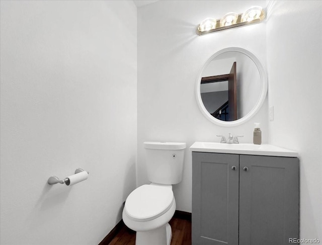 7217 S Zephyr Way, Littleton, CO 80128 - half bathroom featuring toilet, vanity, wood finished floors, and baseboards