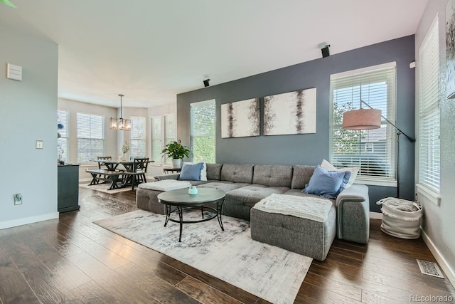 living room featuring a chandelier and dark wood-type flooring