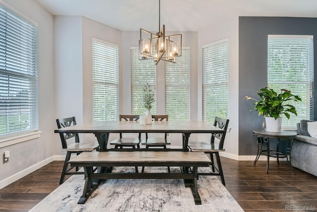 dining space with dark hardwood / wood-style flooring, plenty of natural light, and a notable chandelier