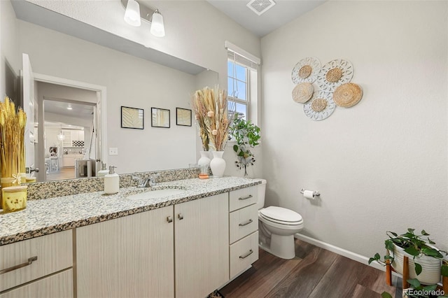 bathroom with hardwood / wood-style flooring, vanity, and toilet