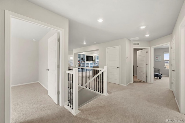 hallway featuring light colored carpet