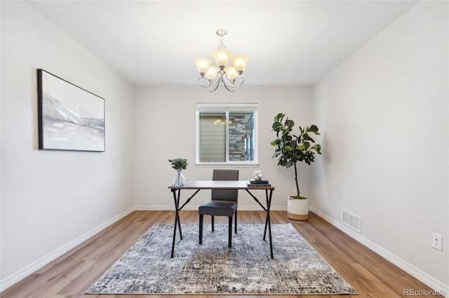 office with an inviting chandelier and light hardwood / wood-style flooring