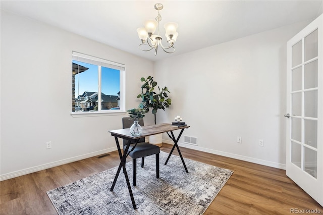 office area featuring an inviting chandelier and hardwood / wood-style flooring